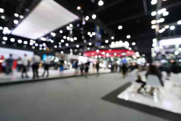 Visiteurs d'un salon professionnel devant une borne photo sur un stand